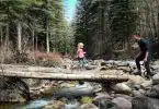 girl crossing wood lumber bridge