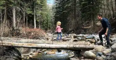 girl crossing wood lumber bridge